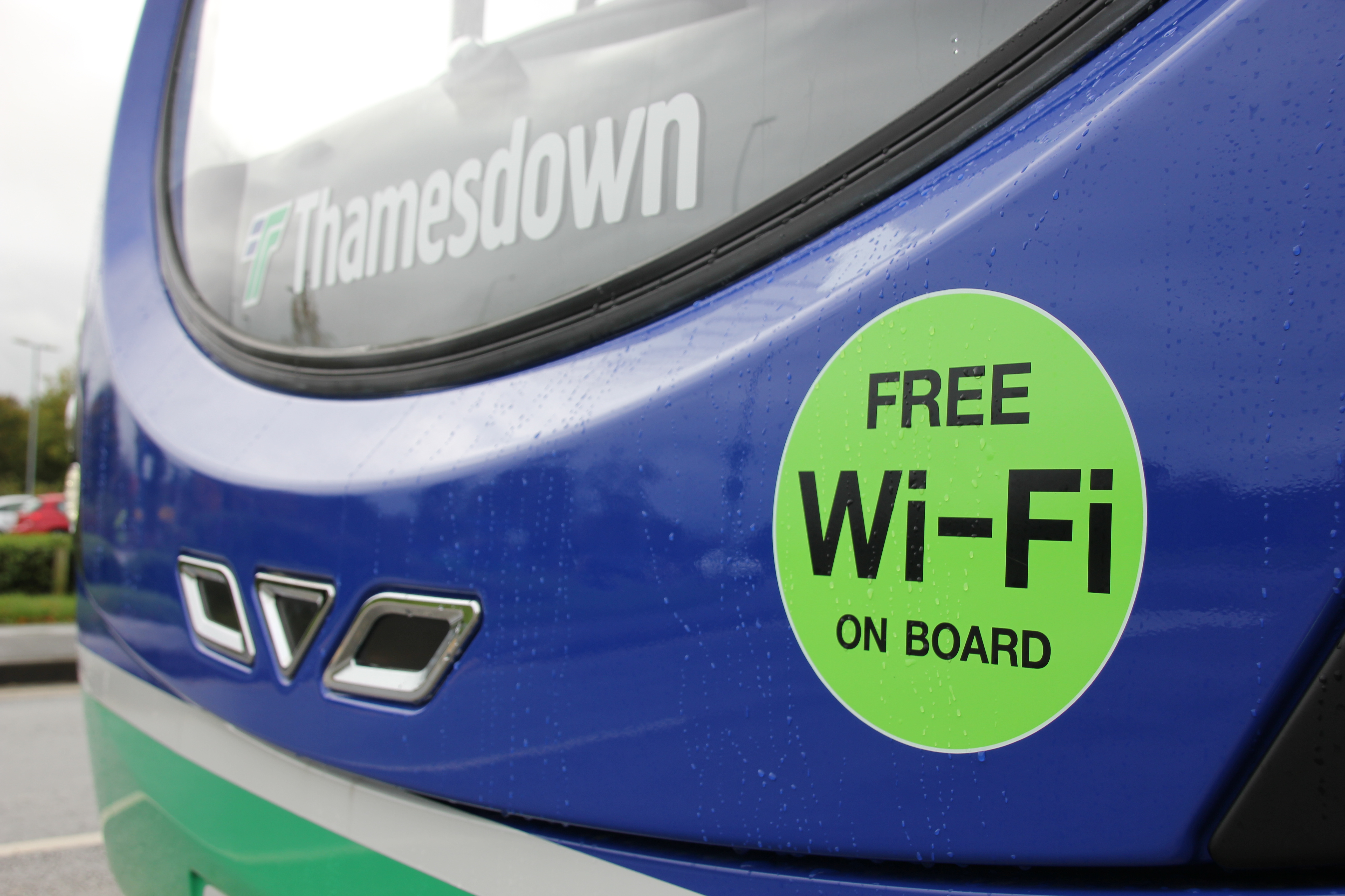 Close up photo of the front of a bus, with a circular 'Free WIFI on board' sign on it.