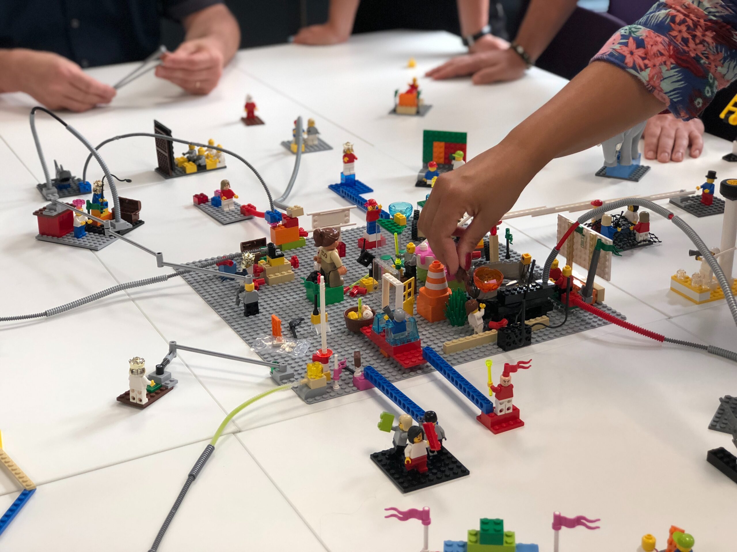 People around a table work on a Lego model