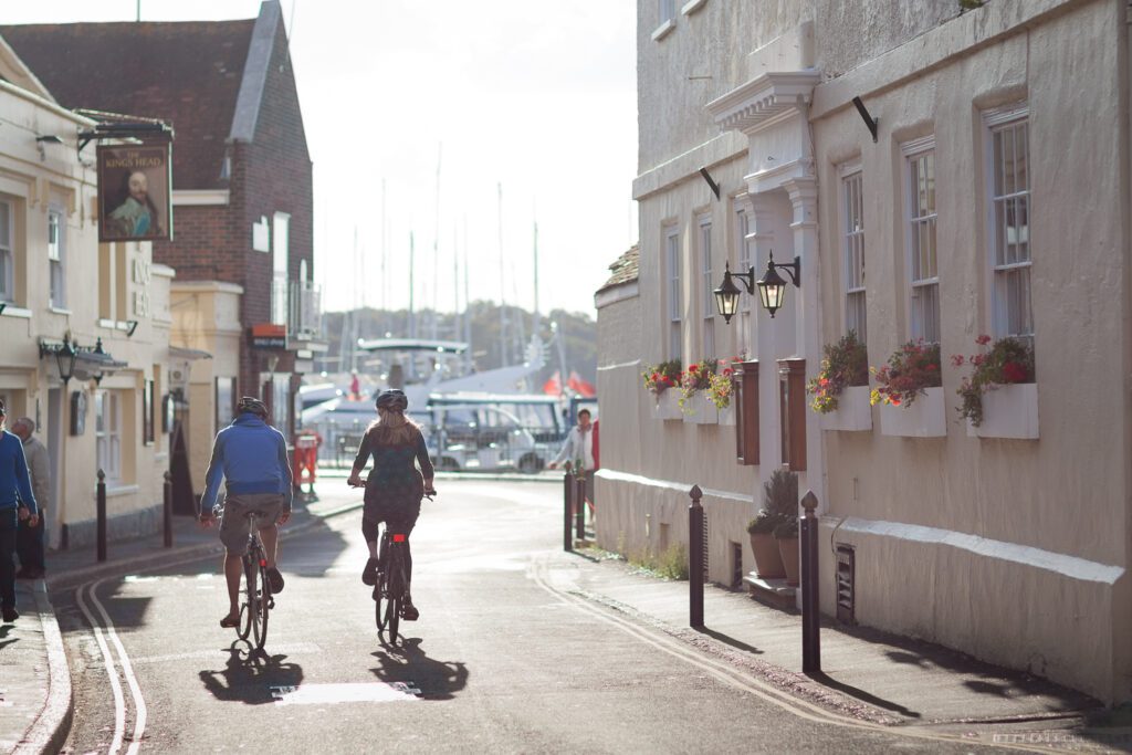 A woman and man cycle through the street in Yarmouth, Isle of Wight.